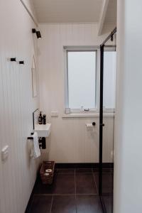 a bathroom with a shower and a sink and a window at Wallinga Farmstay Mudgee in Mudgee