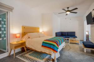 a bedroom with a bed and a blue couch at Riberas Suites in Chapala