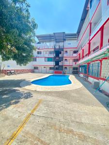 un bâtiment avec une piscine en face d'un bâtiment dans l'établissement Hotel Maria Bonita Acapulco, à Acapulco