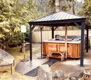 una bañera de hidromasaje bajo un cenador en un jardín en Bramblebank Cottages en Harrison Hot Springs