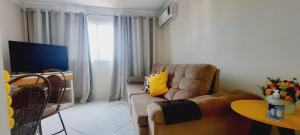 sala de estar con sofá y TV en Apto Super confortável com Wifi en Guarapari