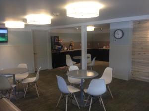 - une salle d'attente avec des tables, des chaises et une horloge dans l'établissement Basalt Mountain Inn, à Basalt