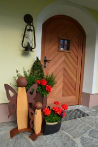 een houten deur met bloemen ervoor bij Möselberghof in Abtenau