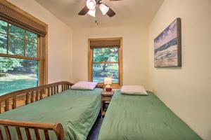 two twin beds in a room with a window at Waterfront Leech Lake Cabin with Dock, Fire Pit in Cass Lake