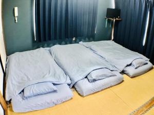 a pile of white pillows sitting on top of a bed at Habitacion NIIYA Mt Fuji in Fujikawaguchiko