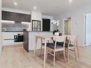 kuchnia ze stołem i krzesłami w kuchni w obiekcie Brand New Lux 2 Bedroom Apartment w Auckland
