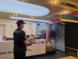 un hombre está sosteniendo una máquina en una habitación en Golden Business Hotel, en Jinju
