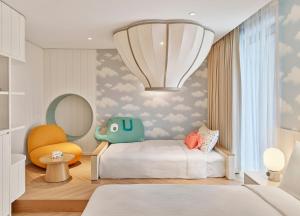 a bedroom with a bed and a chair and a mirror at Grand Josun Busan in Busan