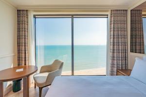 a hotel room with a bed and a view of the ocean at Grand Josun Busan in Busan