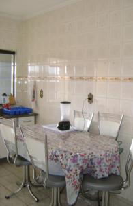 una cocina con una mesa con sillas y una batidora. en Apartamento Guarulhos, en Guarulhos