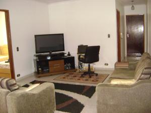 a living room with two couches and a flat screen tv at Apartamento Guarulhos in Guarulhos