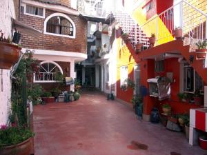 un callejón con edificios rojos y blancos y macetas en La Cabaña en Huaraz