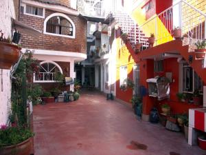 un vicolo con edifici rossi e bianchi e piante in vaso di La Cabaña a Huaraz