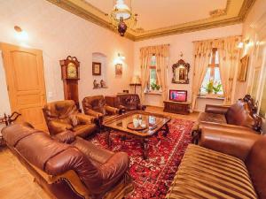 a living room with leather furniture and a table at Pałac Kursko in Kursko