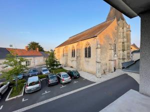 eine Gruppe von Autos, die vor einer Kirche geparkt sind in der Unterkunft Gîte au pied du château de Chaumont-Sur-Loire, Chambord et Amboise in Onzain