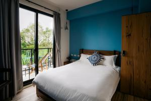 Un dormitorio con una cama con una pared azul. en 禾田遇民宿 Hetianyu, en Sanxing 54 fotos más