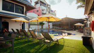 a group of chairs and umbrellas next to a pool at The Yorkshire Hotel - SHA Certified in Patong Beach