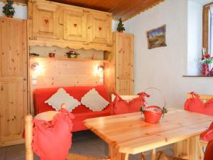 a living room with a table and a red couch at Studio Valloire, 1 pièce, 4 personnes - FR-1-263-81 in Valloire