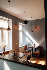 una sala da pranzo con tavolo, sedie e finestre di Oskars Absteige a Lipsia