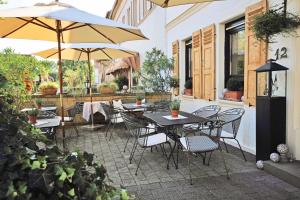 an outdoor patio with tables and chairs and umbrellas at Hotel Pfälzer Hof in Lauterecken