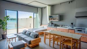 eine Küche und ein Wohnzimmer mit Meerblick in der Unterkunft Feliz Villa Suite Kourijima View in Nago