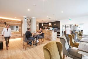 un grupo de personas sentadas en una mesa en un restaurante en Zum Landsberger Hof en Arnsberg