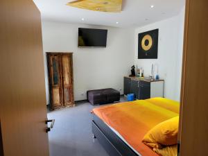 sypialnia z łóżkiem i telewizorem na ścianie w obiekcie Travelers Home w mieście Hasloch