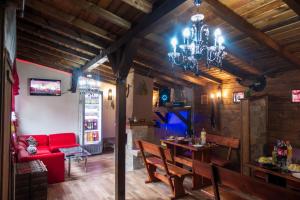 a dining room with a red couch and a chandelier at Guest House Markovi in Govedartsi