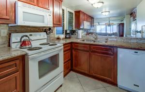 uma cozinha com electrodomésticos brancos e armários de madeira em Hanalei Bay Resort 6102 condo em Princeville