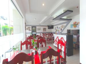 OYO 567 Blue Horizon Hostel في دوماغيتي: مطعم بكراسي حمراء وطاولة في الغرفة
