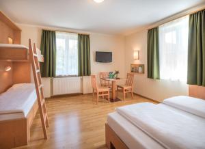 Cette chambre comprend 2 lits superposés et une table. dans l'établissement JUFA Hotel Altaussee, à Altaussee