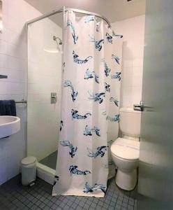 a bathroom with a shower curtain with a toilet at Boardrider Backpackers and Budget Motel in Sydney