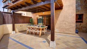 an outdoor patio with a wooden table and chairs at Tinajas Chic in Corralejo