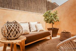 a couch on a patio with a potted plant at Tinajas Chic in Corralejo