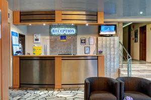 a hotel lobby with a reception desk and two chairs at Paloma - in the center of the city in Sunny Beach +27 photos