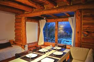 een eetkamer met 2 tafels en een raam bij La Campiña in Bariloche