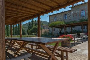 a wooden picnic table under a wooden pergola at RICASOLI, Brolio Agriroom in Gaiole in Chianti