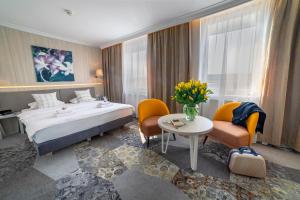 Una habitación de hotel con una cama, una mesa y sillas. en Hotel Victoria, en Lublin