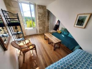 a room with a bed and a couch and a table at Gîte de La Tronchoyse entre vins et nature in Tronchoy