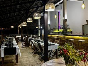 a dining room with tables and chairs and lights at Hotel Océan Beach Sakatia in Nosy Be