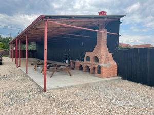 einen Pavillon mit einem Picknicktisch und einem Steinofen in der Unterkunft Vila Ekooos in Braşov + 11 Fotos