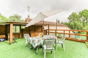 eine Terrasse mit einem Tisch, Stühlen und einem Sonnenschirm in der Unterkunft Le Pardoux in Saint-Pardoux