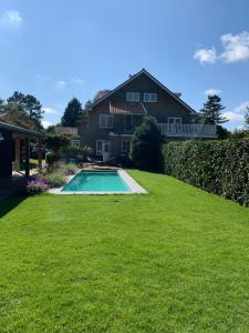 a yard with a swimming pool in front of a house at Chalet Santpoort-Zuid in Santpoort-Zuid