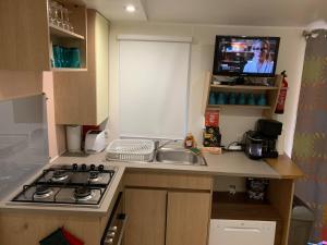 
A kitchen or kitchenette at Les Sables du Midi MobileHome 8P CLIM 4 étoiles
