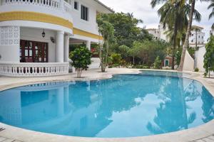 a swimming pool in front of a house at Tahira Villa in Diani Beach