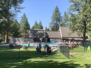 a group of people standing around a swimming pool at River Ridge 416B condo in Bend