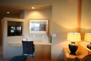 a room with a desk and a tv and a lamp at River Ridge 416B condo in Bend