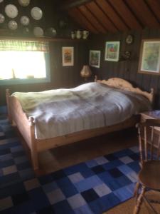 um quarto com uma cama grande num quarto em Egen stuga med delat badrum em Norrtälje