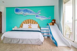 Un dormitorio con una pared azul con una cama y un tobogán en Footprint Garden B&B, en Dongshan