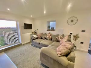 uma sala de estar com um sofá e uma grande janela em Clover Lodge em Chesterfield